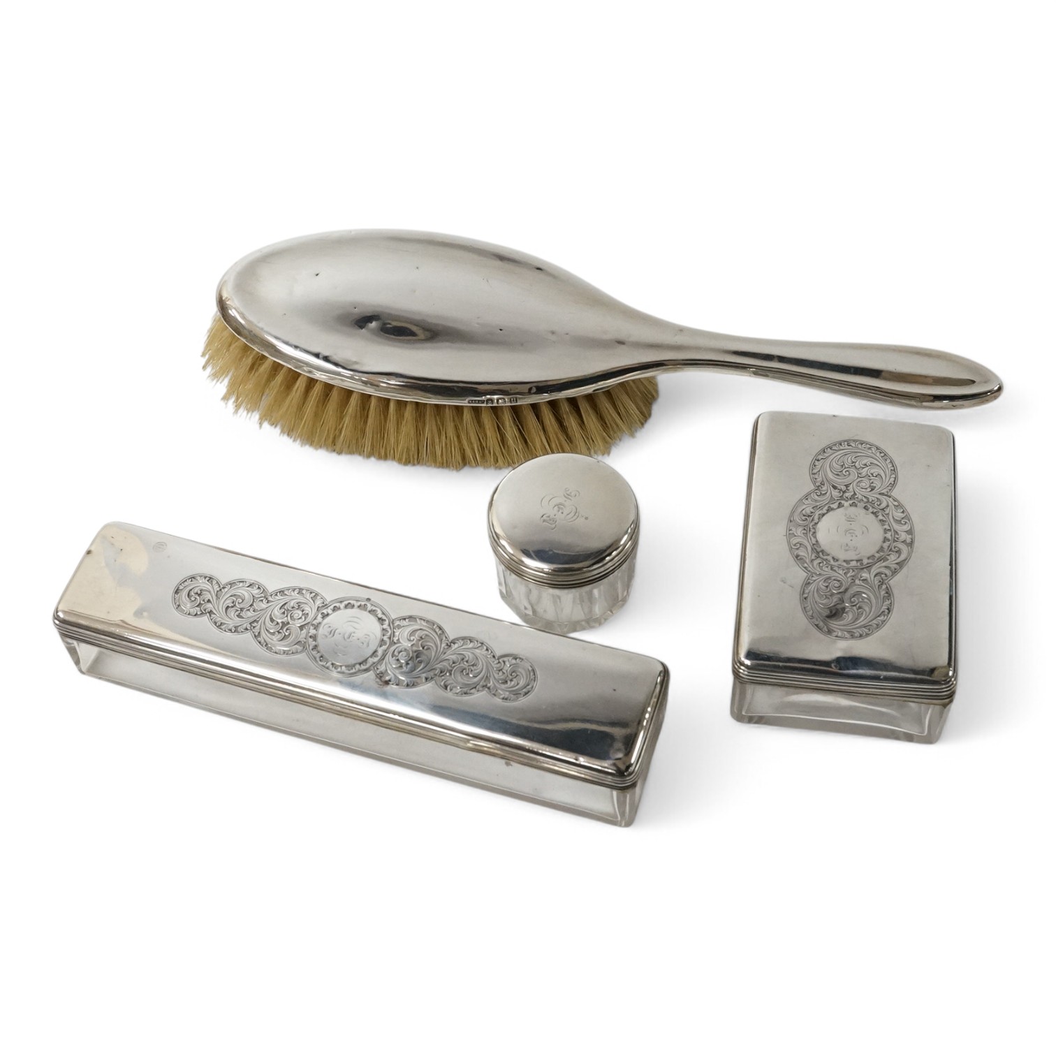 A 19th century Dutch white metal octagonal vinaigrette, with engraved geometric decoration, 51mm, together with two William IV silver mounted glass toilet jars, George Reid, London, 1834, one other later silver mounted g
